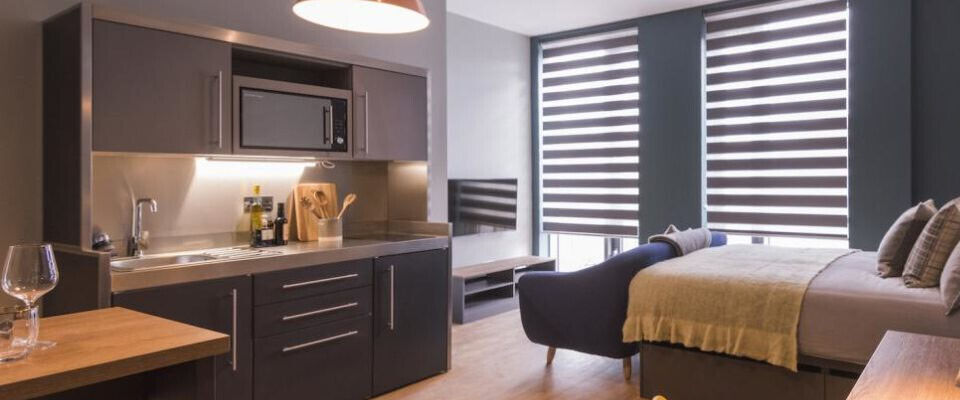 Stalen mini keuken in studentenwoning met apparatuur en bovenkasten